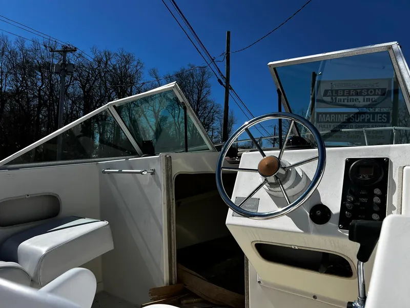 Slide: The Image of 1979 Aquasport 22-2 boat interior with steering wheel and seating under clear blue sky. - 7