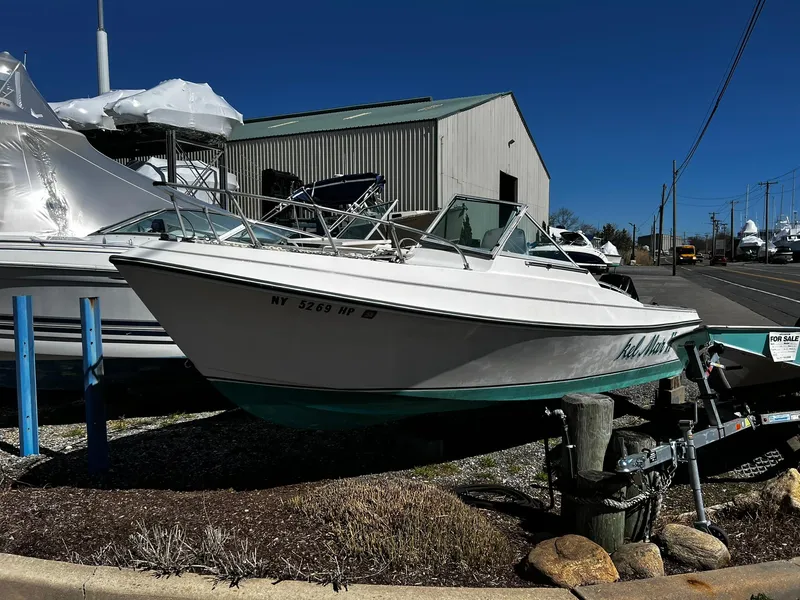 Slide: The Image of 1979 Aquasport 22-2 boat on trailer, parked near marina buildings. - 8