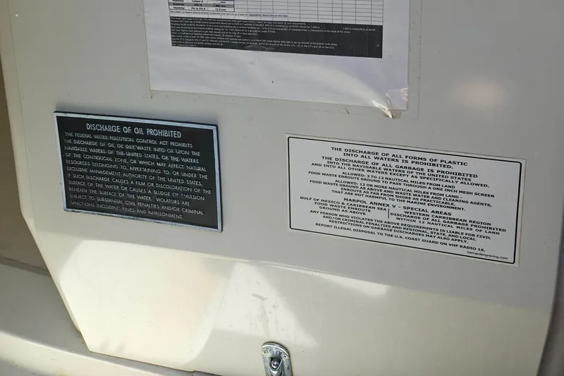 Slide: The Image of Notices on a C&C Mega 30 One Design boat, prohibiting oil and plastic discharge. - 14