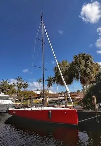 Slide: The Image of Red C&C Mega 30 One Design sailboat docked, 2014 model, under a clear blue sky. - 2