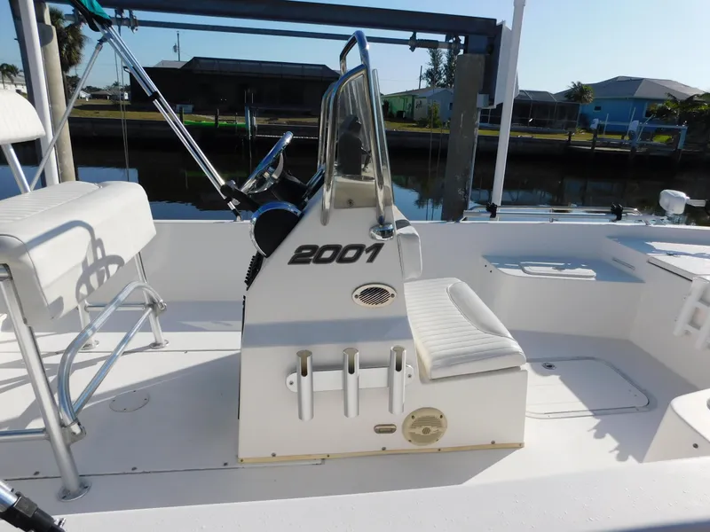 Slide: The Image of Century 2001 Bay CC boat interior, featuring steering console and seating, docked by a canal. - 10
