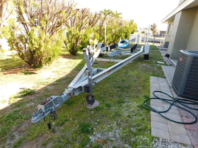 Slide: The Image of Trailer for 2014 Century 2001 Bay CC boat parked on grass near a building. - 14
