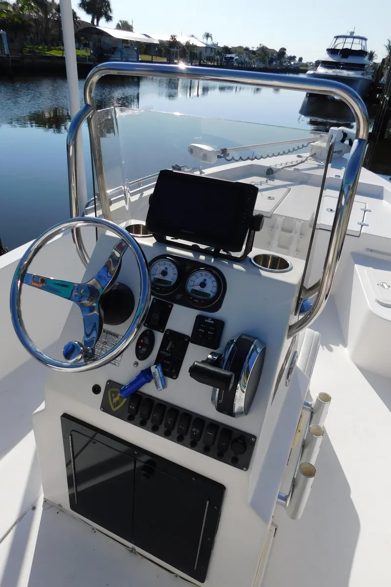 Slide: The Image of Century 2001 Bay CC boat console, 2014 model, with steering wheel and gauges, docked by a serene waterway. - 18