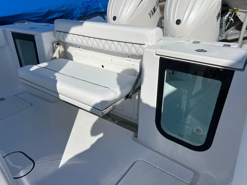Slide: The Image of 2025 Sportsman Open 262 Center Console boat interior with white seating and storage compartments. - 18