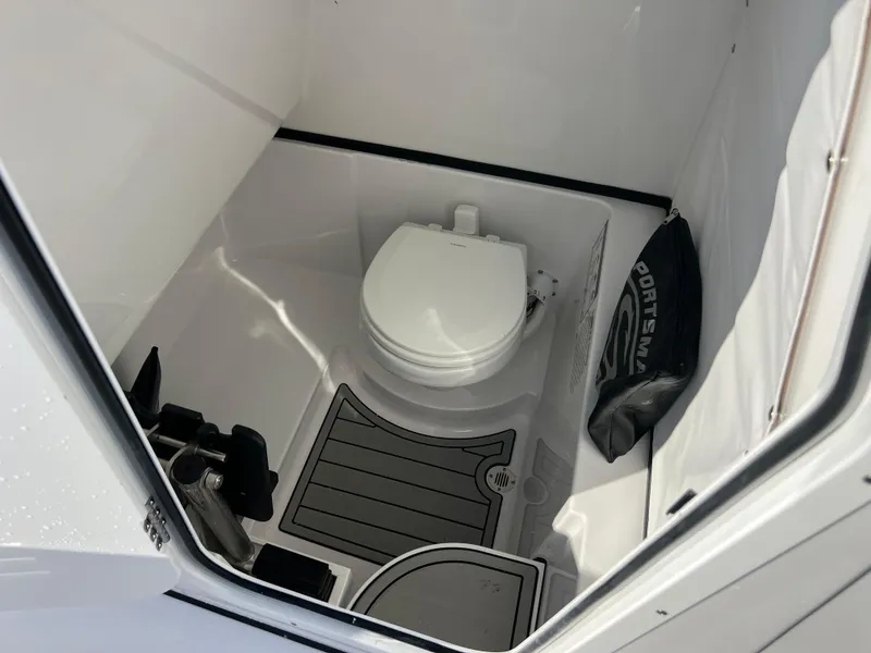 Slide: The Image of 2025 Sportsman Open 262 Center Console boat interior with toilet and storage area. - 19