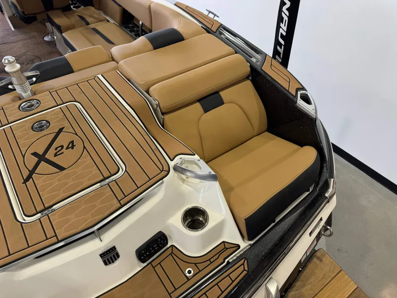 Slide: The Image of 2021 MasterCraft X24 boat interior with tan and black seating, featuring stylish deck design. - 10