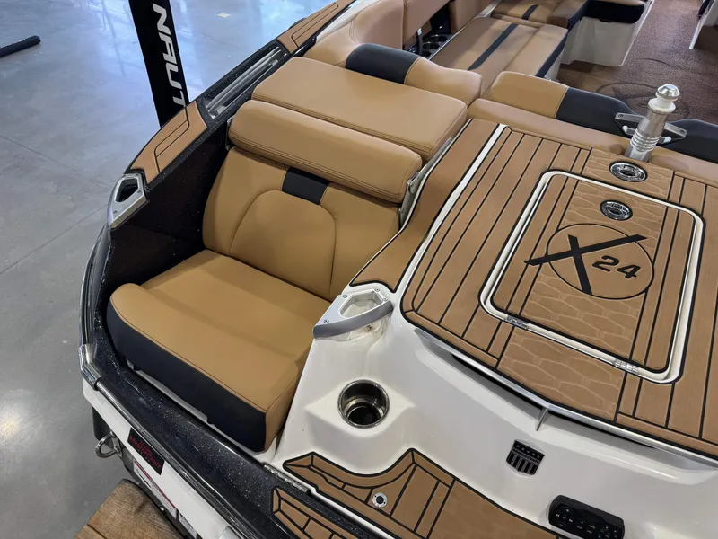 Slide: The Image of 2021 MasterCraft X24 boat interior with tan seating and deck, showcasing luxury design. - 11