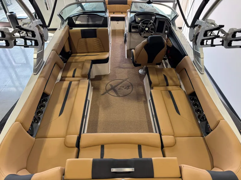 Slide: The Image of 2021 MasterCraft X24 boat interior with tan seating and modern dashboard. - 15