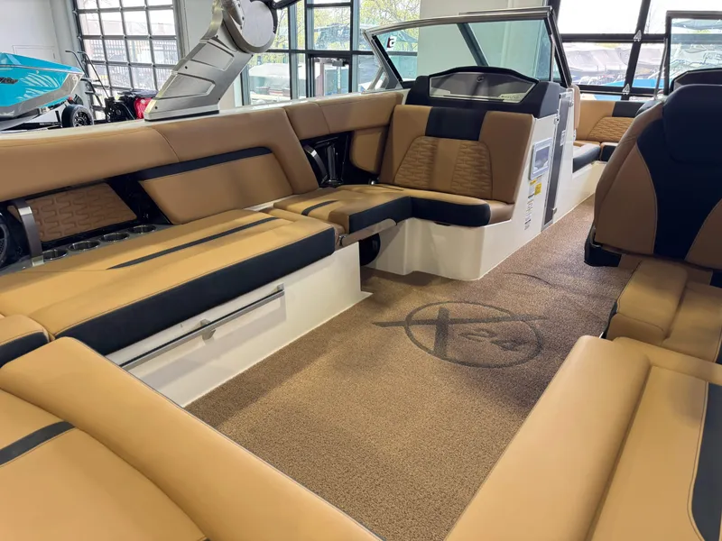 Slide: The Image of 2021 MasterCraft X24 boat interior with tan and black seating, spacious layout, and modern design. - 16
