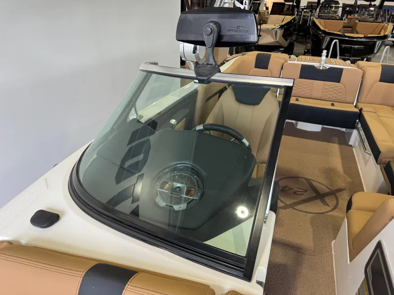 Slide: The Image of 2021 MasterCraft X24 boat interior with tan seating and steering wheel. - 22