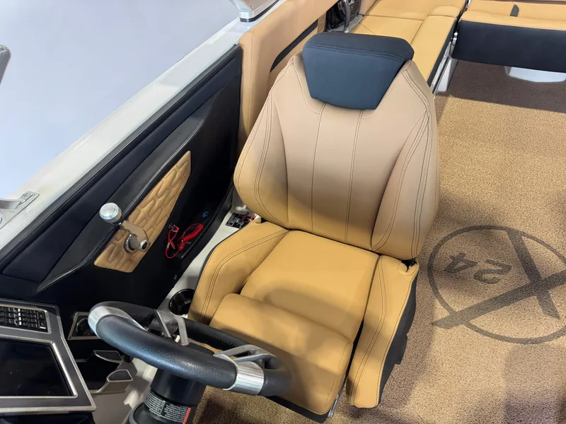 Slide: The Image of Captain's seat in 2021 MasterCraft X24 boat, featuring tan upholstery and sleek design. - 23