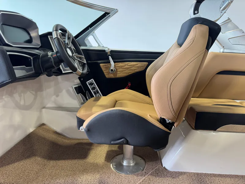 Slide: The Image of 2021 MasterCraft X24 interior with tan captain's seat and modern steering wheel. - 25
