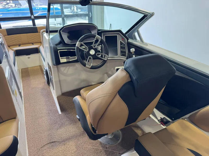 Slide: The Image of 2021 MasterCraft X24 boat interior with steering wheel and tan seating. - 26