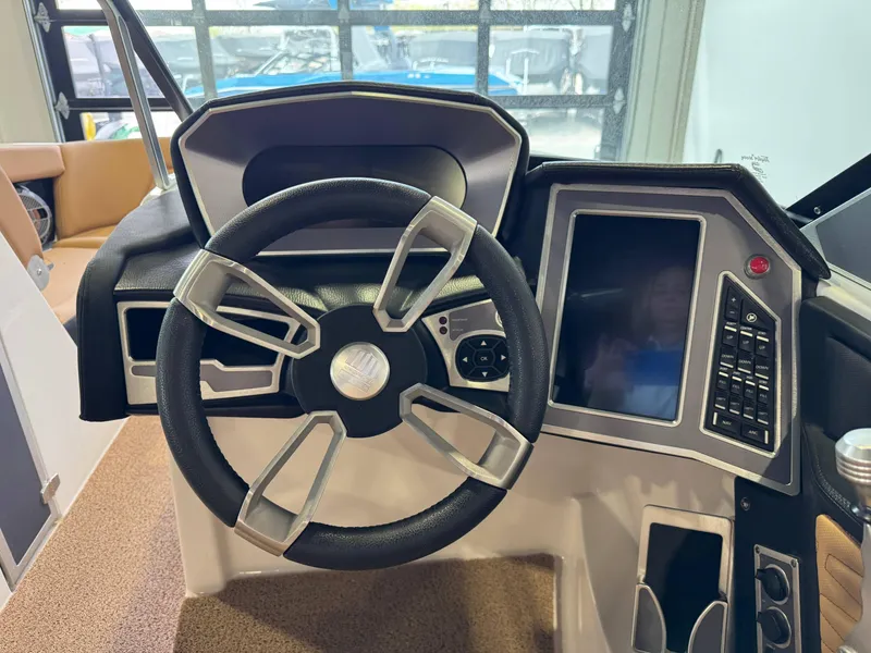 Slide: The Image of 2021 MasterCraft X24 boat dashboard with steering wheel and touchscreen controls. - 28