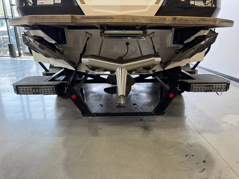 Slide: The Image of Rear view of a 2021 MasterCraft X24 boat on a trailer indoors. - 6