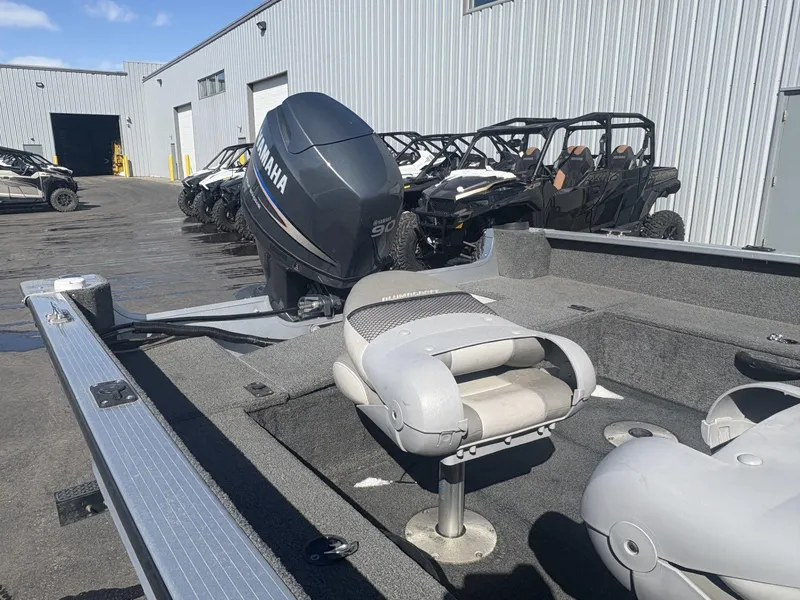 Slide: The Image of 2007 Alumacraft Navigator 165 CS boat with Yamaha engine, parked near off-road vehicles. - 11