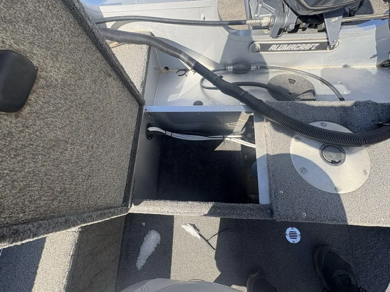 Slide: The Image of 2007 Alumacraft Navigator 165 CS boat interior with open storage compartment and visible wiring. - 14