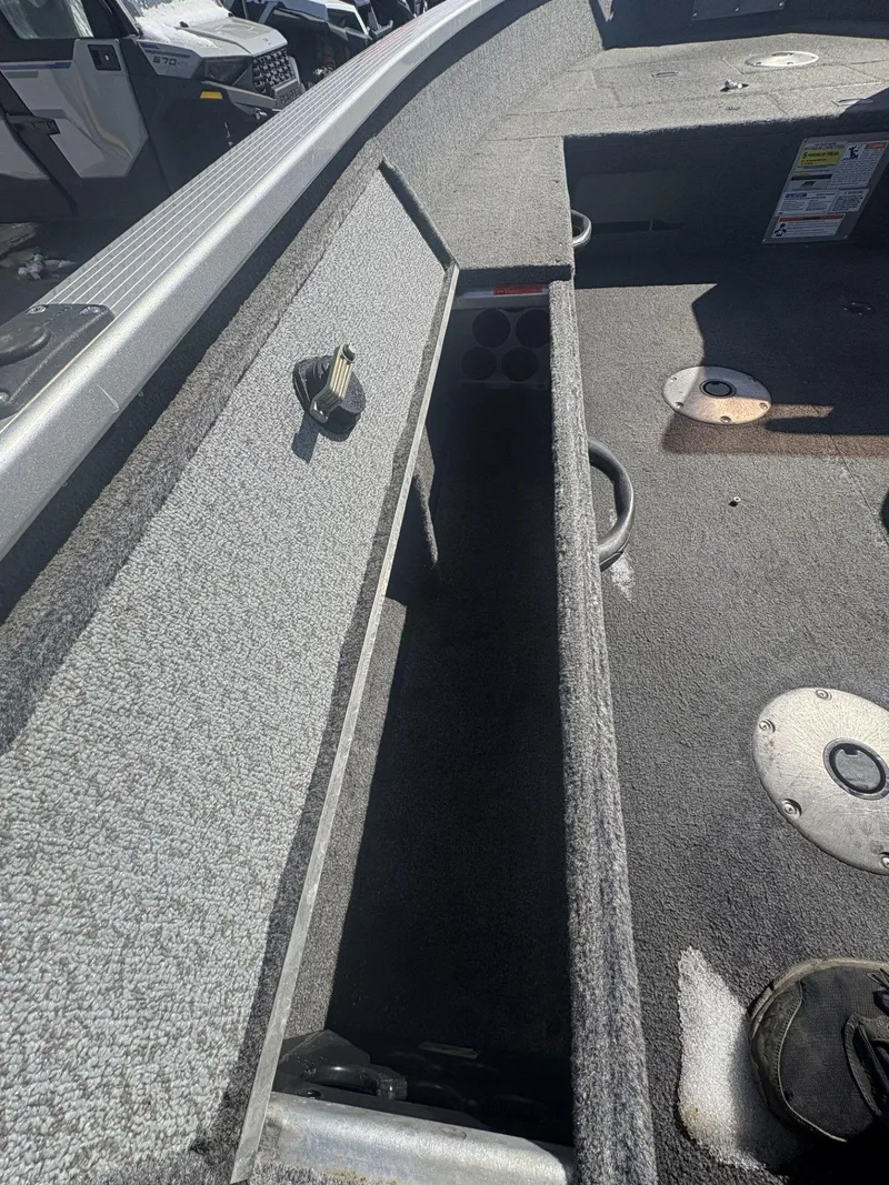 Slide: The Image of 2007 Alumacraft Navigator 165 CS boat interior with storage compartment and carpeted flooring. - 15