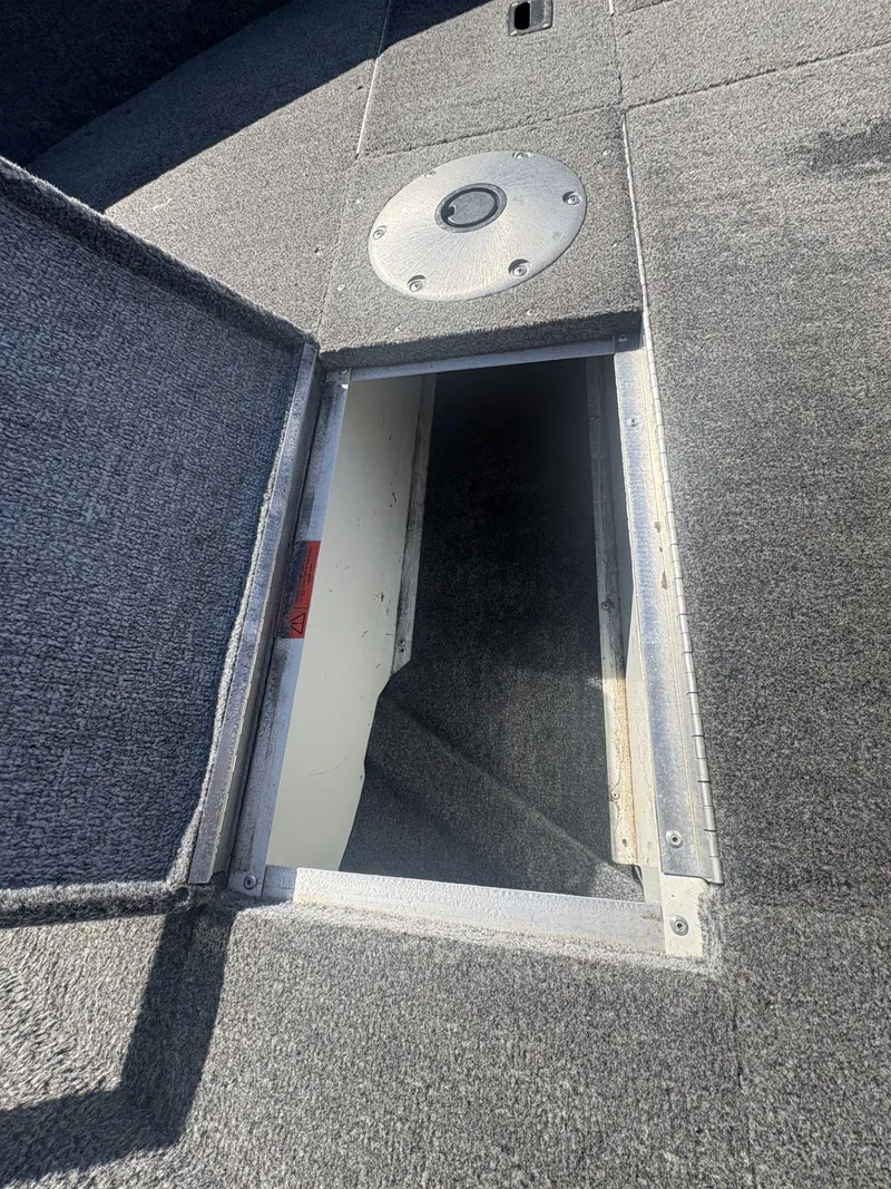 Slide: The Image of Open storage compartment on 2007 Alumacraft Navigator 165 CS boat deck. - 19