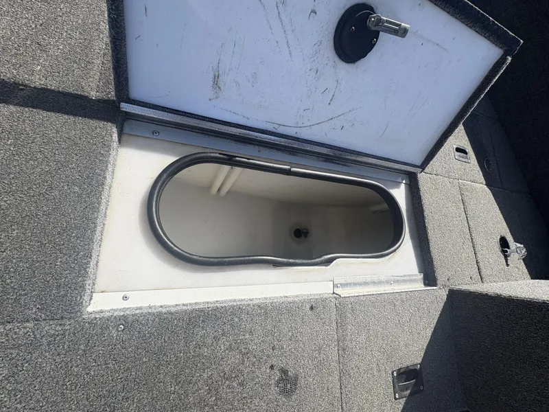 Slide: The Image of 2007 Alumacraft Navigator 165 CS boat storage compartment with open lid, showing interior space. - 23