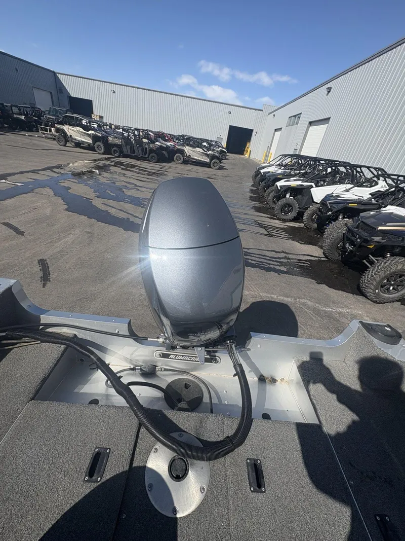 Slide: The Image of 2007 Alumacraft Navigator 165 CS boat with outboard motor in industrial lot. - 27