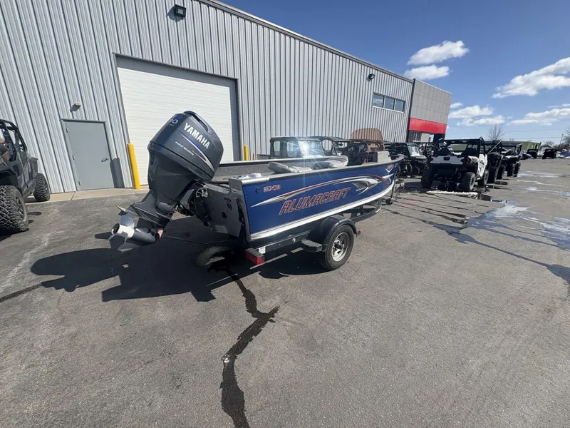 Slide: The Image of 2007 Alumacraft Navigator 165 CS boat with Yamaha motor, parked outside a warehouse. - 5