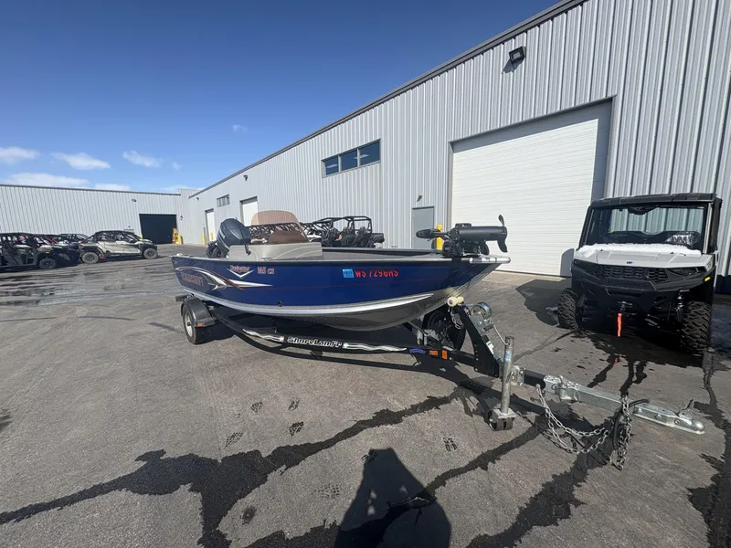 Slide: The Image of 2007 Alumacraft Navigator 165 CS boat on trailer, parked outside industrial building. - 6