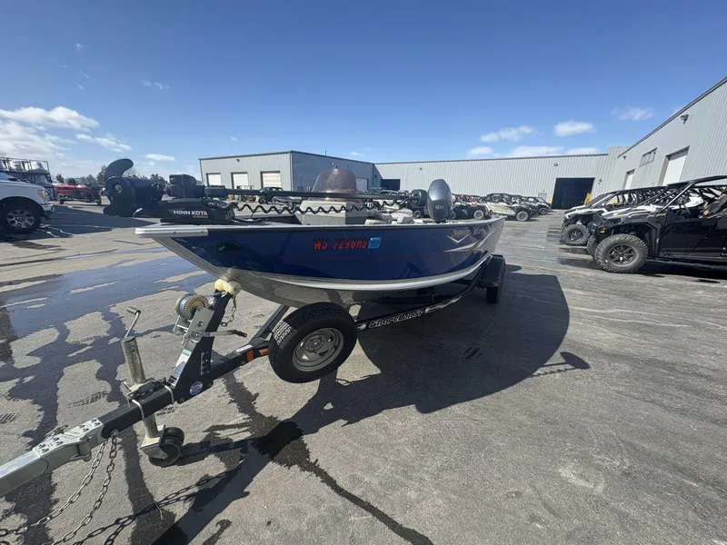 Slide: The Image of 2007 Alumacraft Navigator 165 CS boat on trailer, parked outdoors under clear sky. - 8
