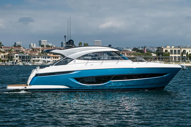 Slide: The Image of 2024 Riviera 4600 Sport Yacht on water, sleek design, modern marina backdrop. - 13