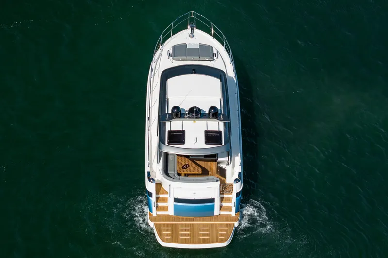 Slide: The Image of 2024 Riviera 4600 Sport Yacht cruising on open water, aerial view. - 19