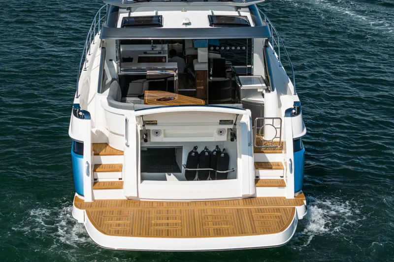 Slide: The Image of 2024 Riviera 4600 Sport Yacht on water, showcasing spacious deck and luxurious interior. - 21