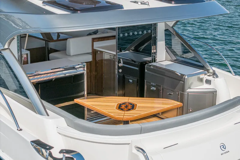 Slide: The Image of 2024 Riviera 4600 Sport Yacht with elegant outdoor seating and sleek design. - 23