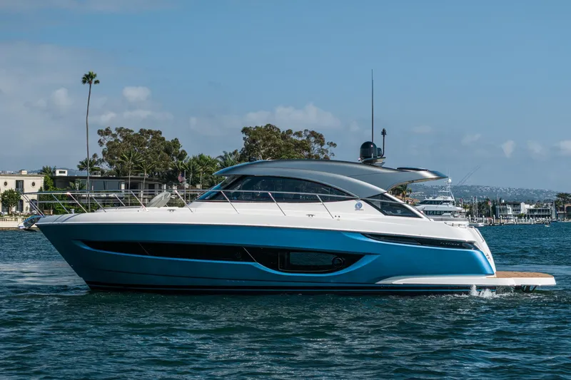 Slide: The Image of 2024 Riviera 4600 Sport Yacht cruising on a sunny day, showcasing sleek design and luxury. - 4