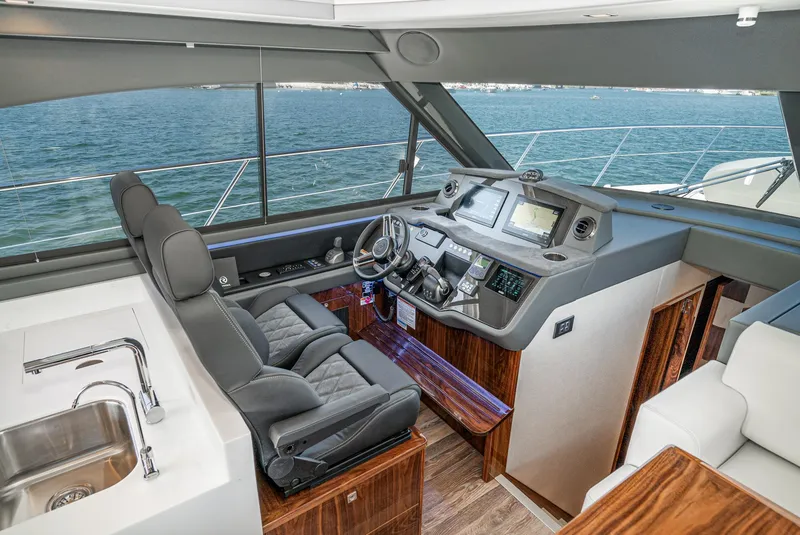 Slide: The Image of 2024 Riviera 4600 Sport Yacht interior with modern helm, leather seating, and ocean view. - 41