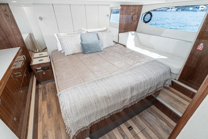Slide: The Image of Luxurious interior of 2024 Riviera 4600 Sport Yacht with elegant wood finishes and spacious bed. - 42
