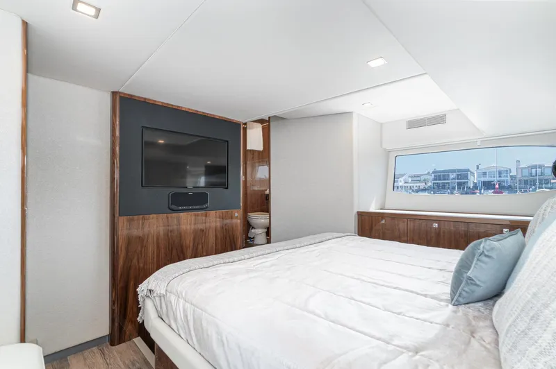 Slide: The Image of Luxurious bedroom interior of 2024 Riviera 4600 Sport Yacht with modern amenities and large window view. - 44