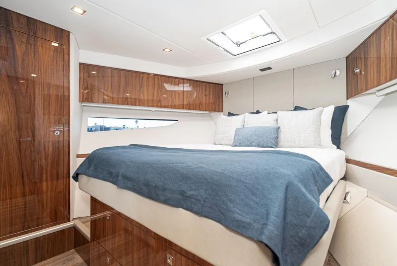 Slide: The Image of Luxurious bedroom interior of 2024 Riviera 4600 Sport Yacht with elegant wood finishes. - 48
