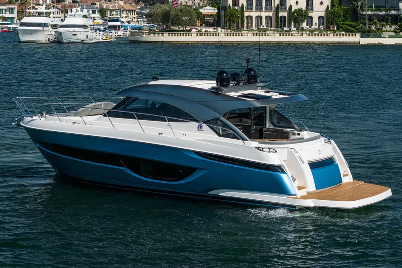 Slide: The Image of 2024 Riviera 4600 Sport Yacht cruising on a sunny day in a scenic harbor. - 7