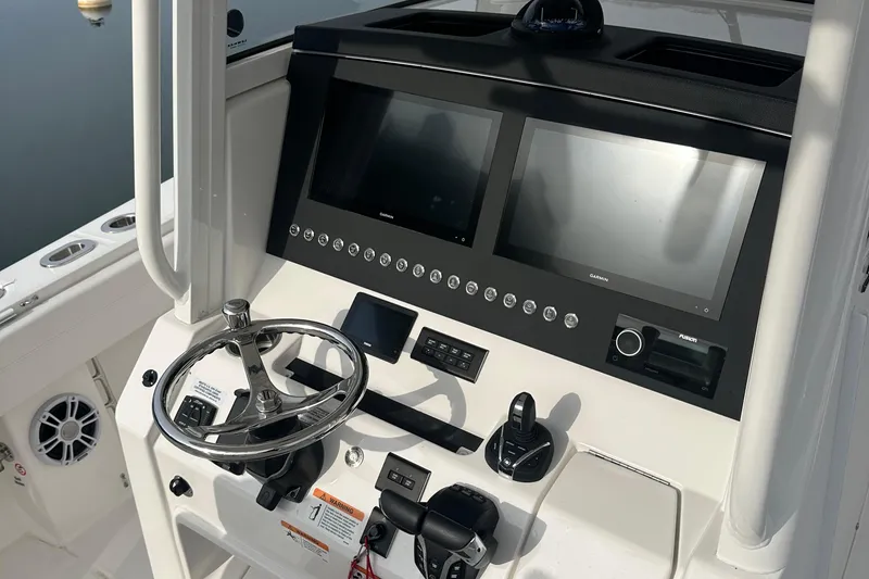 Slide: The Image of 2024 Regulator 31 boat dashboard with dual screens and steering wheel. - 16