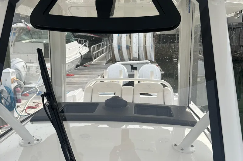 Slide: The Image of 2024 Regulator 31 boat interior with windshield and docked boats in the background. - 19