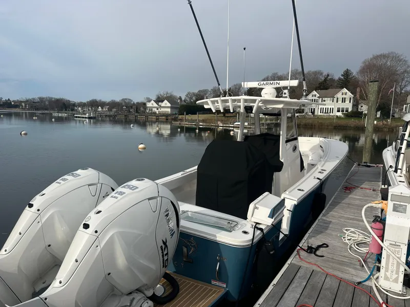 Slide: The Image of 2024 Regulator 31 boat docked, featuring dual engines and Garmin equipment, in a serene waterfront setting. - 3