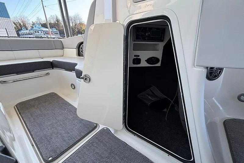 Slide: The Image of 2016 Sea Ray 220 Sundeck Outboard interior with open storage compartment and seating area. - 16