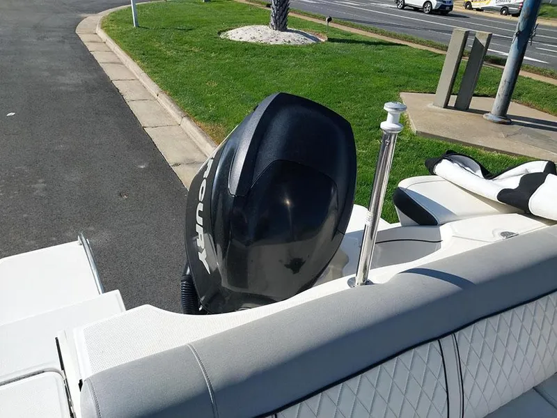 Slide: The Image of 2016 Sea Ray 220 Sundeck Outboard boat with black motor, parked on pavement. - 7