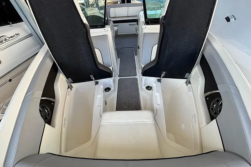 Slide: The Image of 2016 Sea Ray 220 Sundeck Outboard interior with open storage compartments and seating. - 9