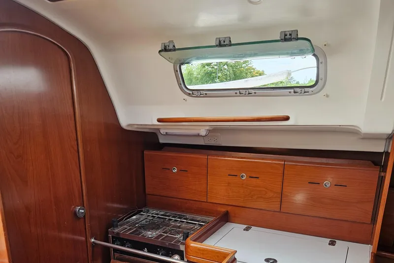 Slide: The Image of Interior of 2006 Beneteau First 36.7 yacht with wooden cabinets and stove. - 32