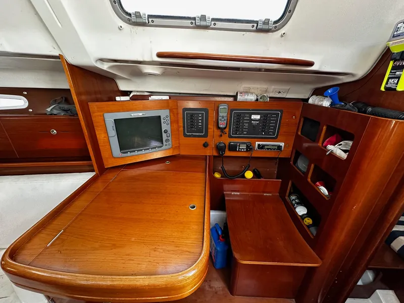 Slide: The Image of Navigation station of 2006 Beneteau First 36.7 yacht with wooden finish and electronic equipment. - 33