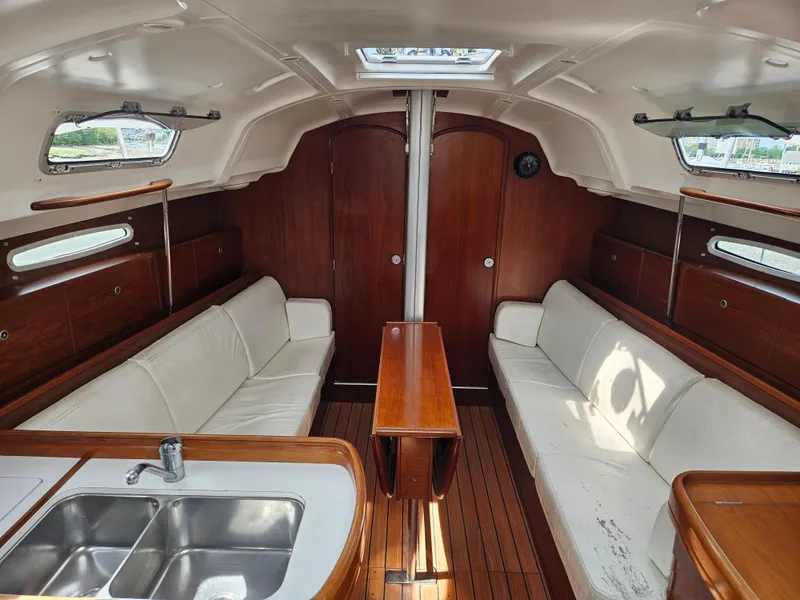 Slide: The Image of Interior of 2006 Beneteau First 36.7 sailboat with wood finish and white seating. - 5