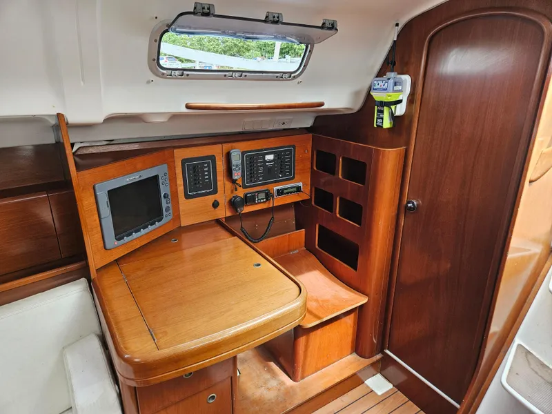 Slide: The Image of 2006 Beneteau First 36.7 yacht interior with navigation equipment and wooden cabinetry. - 8