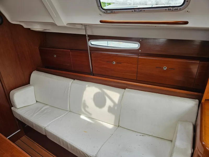 Slide: The Image of Interior of 2006 Beneteau First 36.7 yacht with white sofa and wooden cabinets. - 9