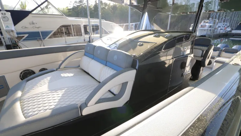 Slide: The Image of 2017 Mystic Powerboats M4200 with sleek design and luxurious seating at a marina. - 13